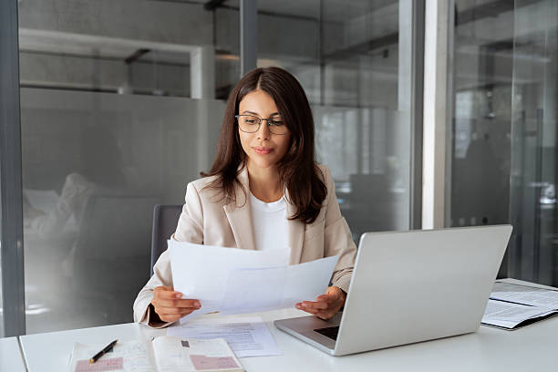 Office manager reviewing financial reports at her desk